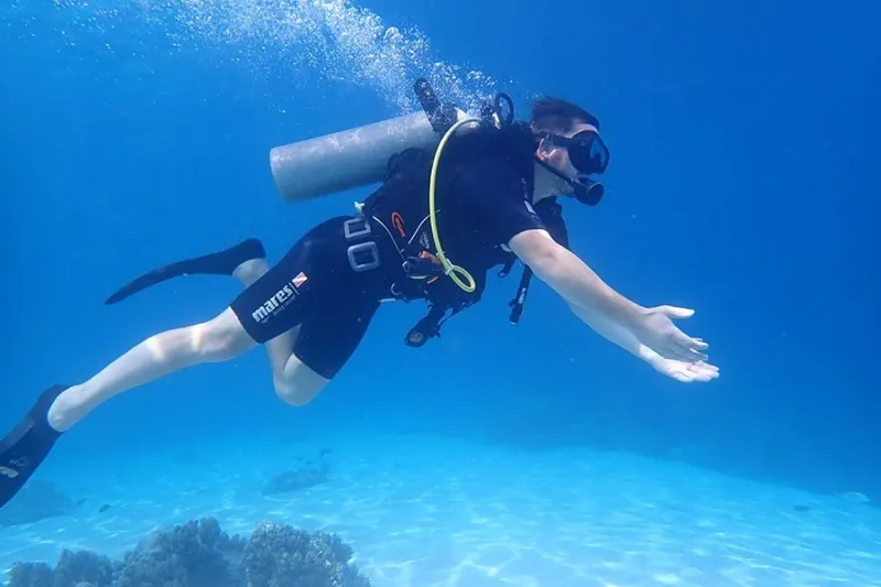 Beginner diver swimming over a sandy bottom in shallow water at Menjangan Island